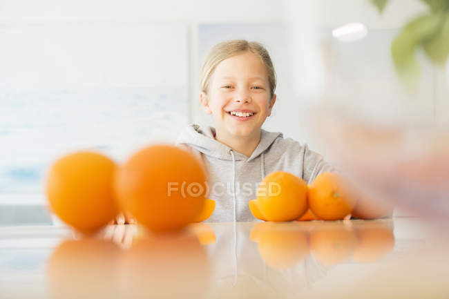 Портрет щасливої дівчини з апельсинами на кухні. — стокове фото