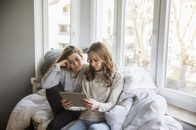 Дві дівчинки-підлітка, використовуючи планшет вдома — стокове фото