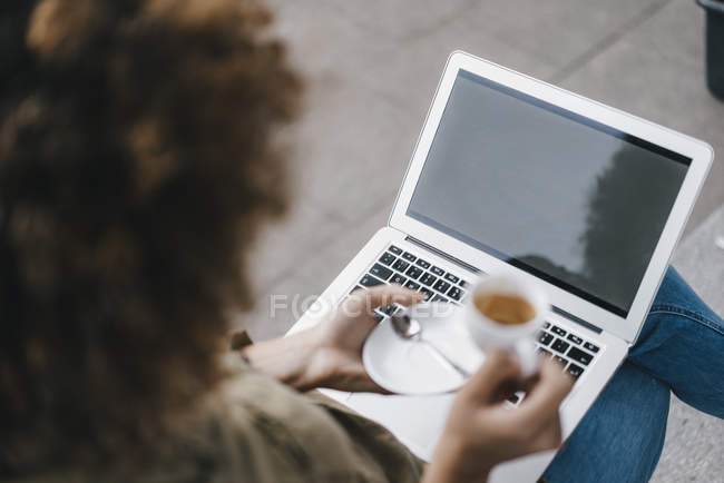 Frau benutzt Laptop, trinkt Kaffee — Stockfoto