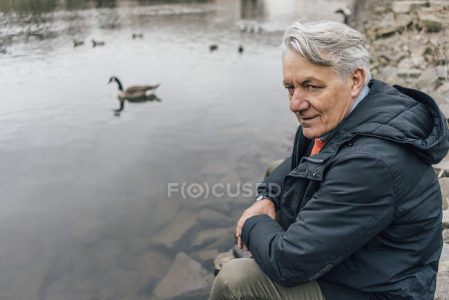 Homme âgé au bord de la rivière regardant de côté — Photo de stock