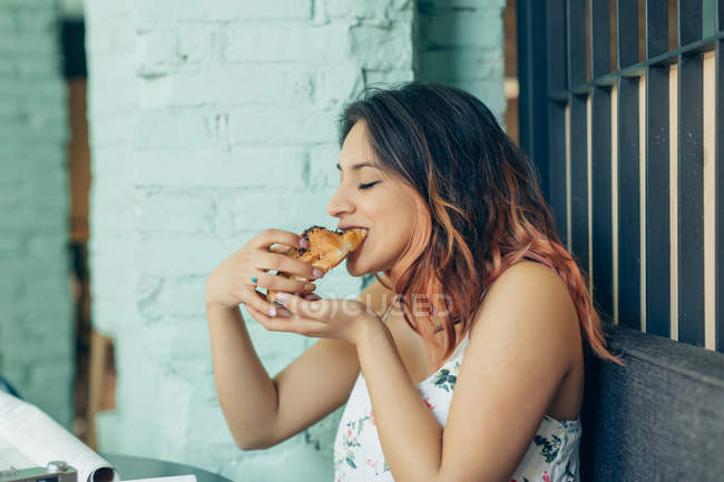 Женщина ест круассан в кофейне — стоковое фото