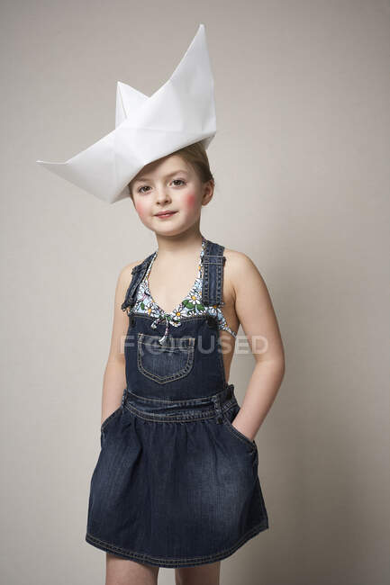 Retrato de niña de moda con gran barco de papel en la cabeza — Stock Photo