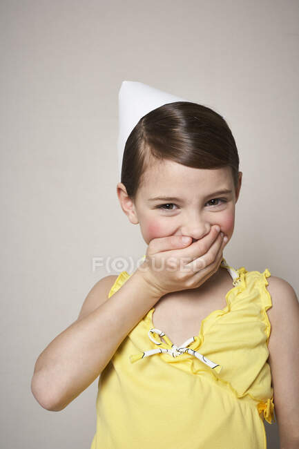 Portrait of laughing little girl wearing paper hat — Stock Photo