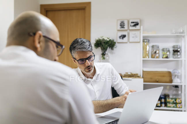 Two colleagues working on laptop at home — Stock Photo