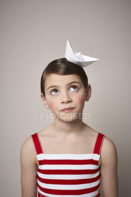Portrait of little girl with paper boat on her head — Stock Photo