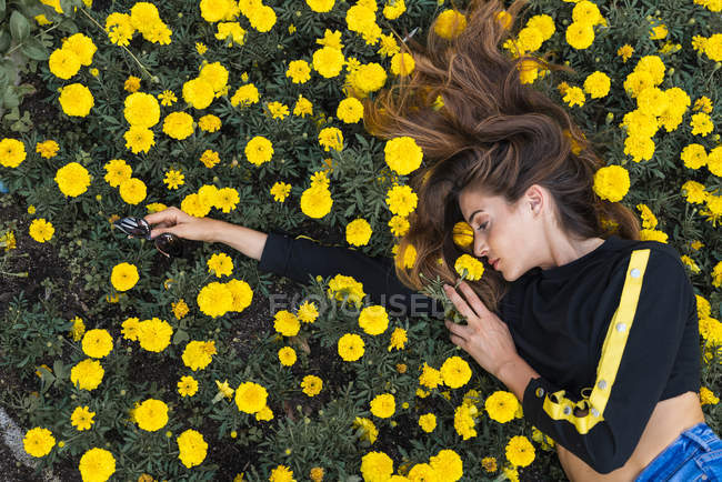 Attractive young woman lying in flower meadow — Stock Photo