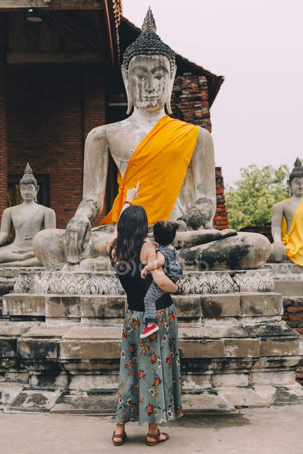 Tailandia, Ayutthaya, vista trasera de la madre y su hija pequeña visitando Wat Yai Chaya Mongkhon - foto de stock