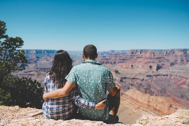 USA, arizona, Grand Canyon Nationalpark, Rückansicht eines Paares, das nebeneinander sitzt und die Aussicht betrachtet — Stockfoto