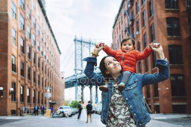 USA, New York, New York, Madre e bambino a Brooklyn con Manhattan Bridge sullo sfondo — Foto stock