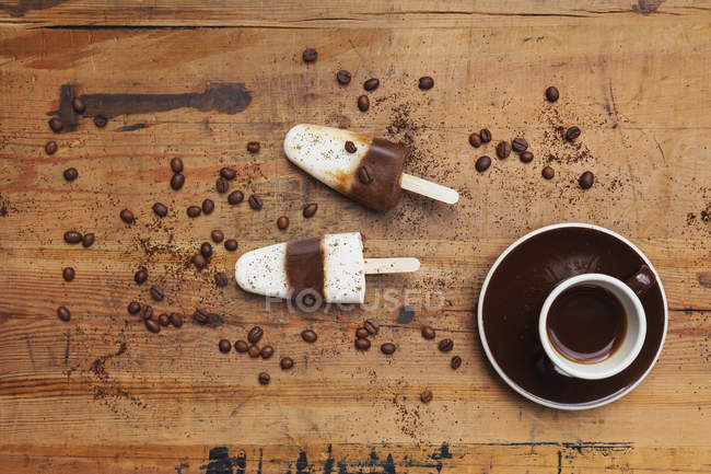 Homemade Espresso Macchiato ice lollies with cup of Espresso and coffee beans on wooden background — Stock Photo
