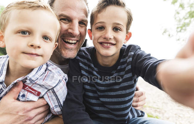 Selfie de padre feliz con dos hijos al aire libre - foto de stock