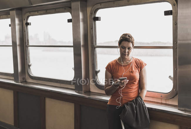 Woman on a ferry looking on cell phone — Stock Photo