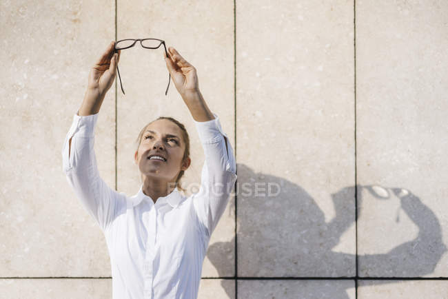 Jovem empresária olhando através de seus óculos — Fotografia de Stock