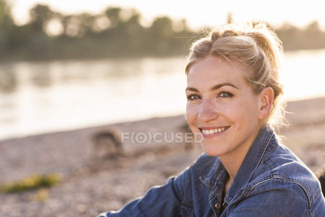 Portrait de femme blonde au bord de la rivière le soir — Photo de stock
