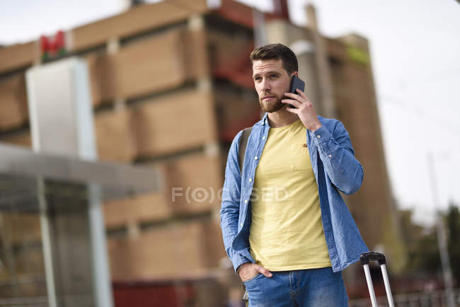 Молодий чоловік зі смартфоном на вокзалі — стокове фото