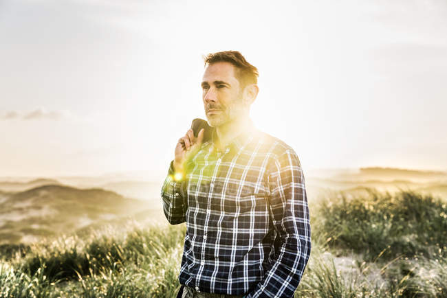 Портрет людини, що стоїть у дюнах на заході сонця — стокове фото