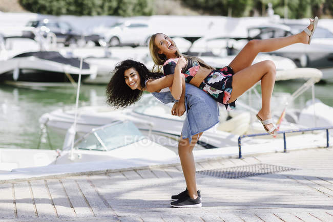 Due giocose giovani donne sul lungomare in estate — Foto stock