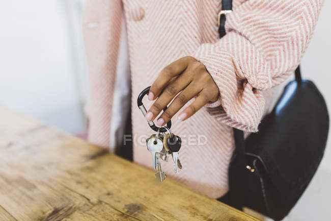 Abgeschnittenes Bild einer Frau, die Schlüssel auf den Tisch legt — Stockfoto