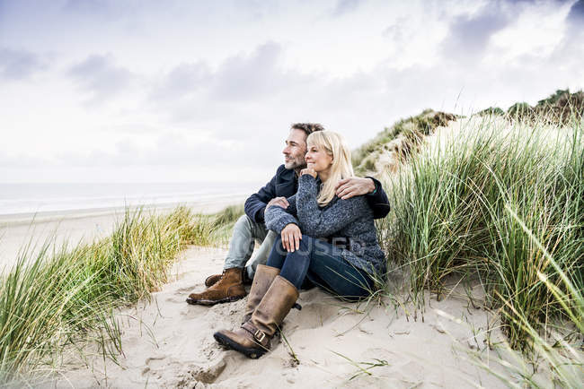 Пара сидящих в дюнах — стоковое фото