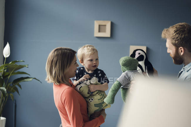 Familia feliz jugando con su hijo en casa - foto de stock