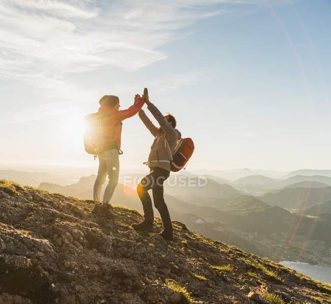 Austria, Salzkammergut, Cheering couple reaching mountain summit — Stock Photo