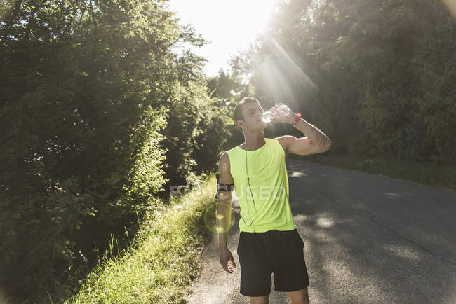 Jogger in the park drinking water — Stock Photo