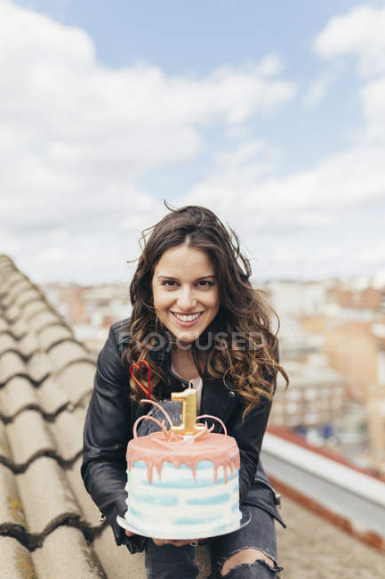 Ritratto di donna che presenta la torta di compleanno sul tetto — Foto stock