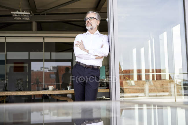 Geschäftsmann steht vor der Tür und denkt — Stockfoto