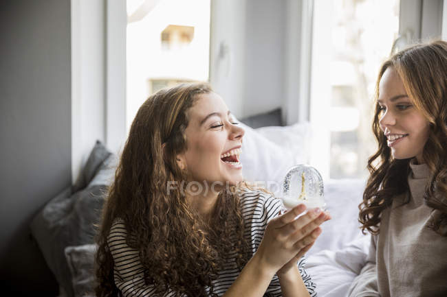 Two happy teenage girls with snow globe — Stock Photo