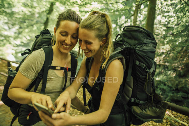 Двоє щасливих молодих жінок подорожують по мобільному телефону — стокове фото
