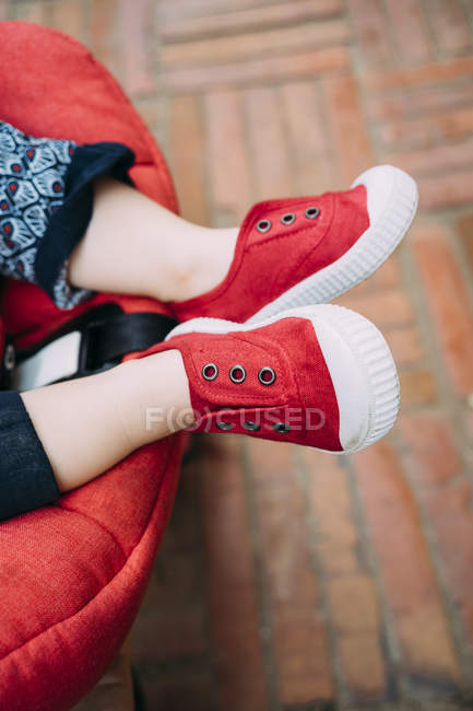 Маленькі лапи з червоними черевиками в колясці. — стокове фото