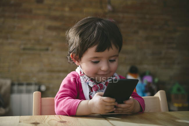 Bebé niña usando el teléfono móvil en casa — Stock Photo