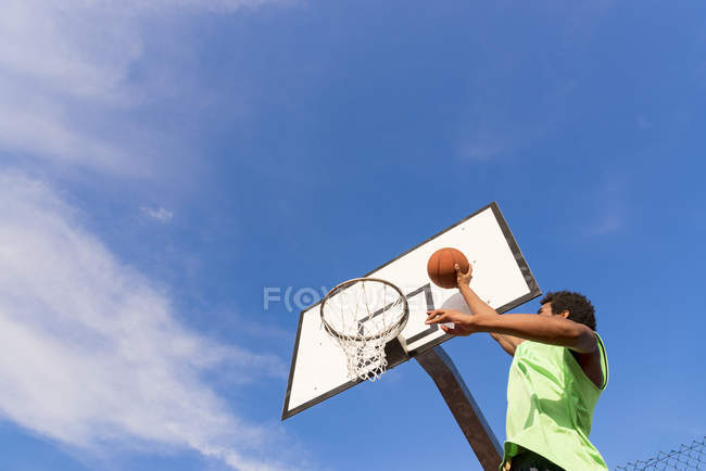 Молодой человек играет в баскетбол — стоковое фото