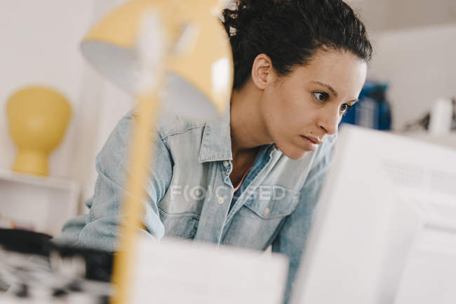Businesswoman working at PC, looking focused — Stock Photo