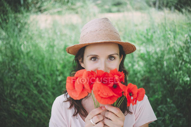 Женщина с букетом красных маков весной — стоковое фото