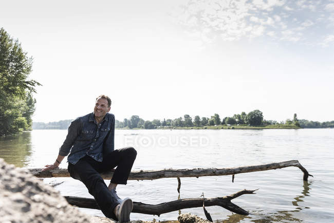 Reifer Mann sitzt am Rheinufer — Stockfoto