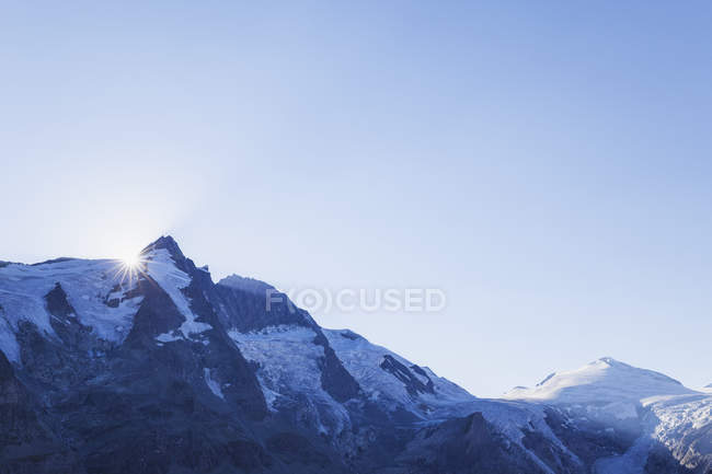 Austria, Carintia, puesta del sol, últimos rayos de sol del día en el pico Grossglockner, a la derecha glaciar Pasterze y Johannisberg, Parque Nacional High Tauern - foto de stock