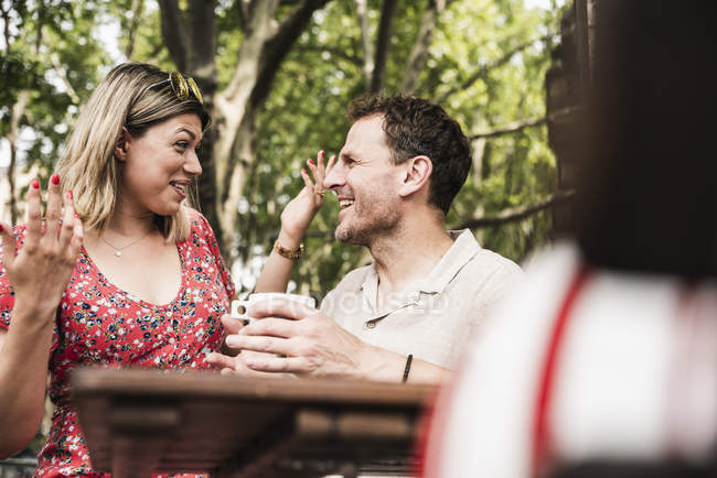 Happy couple talking at an outdoor cafe — Stock Photo