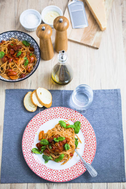 Spaghetti with cherry tomatoes and basil on plate — Stock Photo