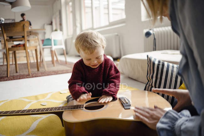 Junge erkundet mit seiner Mutter eine Gitarre — Stockfoto