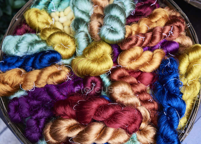 Beaucoup de fibres de soie colorées dans un panier — Photo de stock