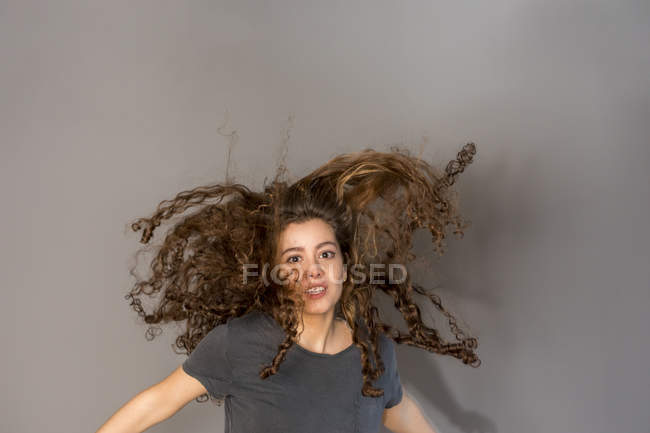 Menina adolescente bonita com cabelo encaracolado, pulando — Fotografia de Stock