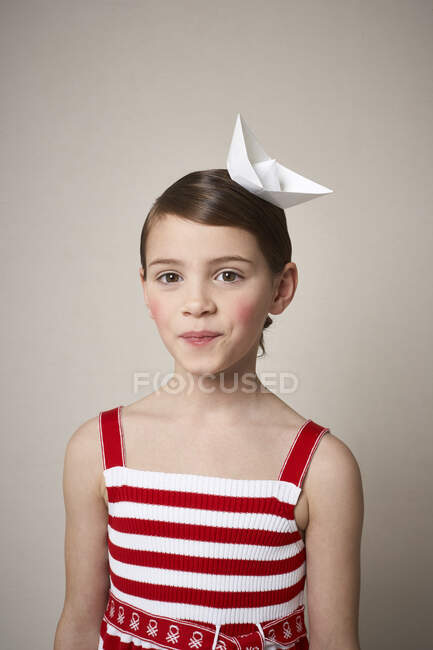 Porträt eines kleinen Mädchens mit Papierboot auf dem Kopf — Stockfoto
