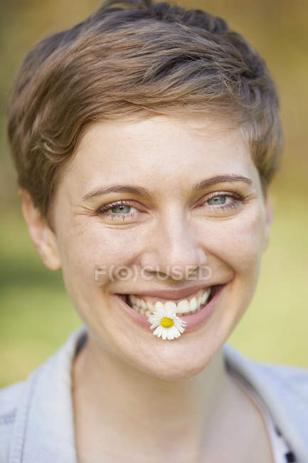 Retrato de mulher rindo com margarida na boca — Fotografia de Stock