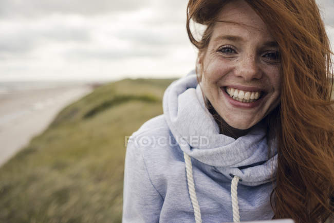 Donna dai capelli rossi godendo di aria fresca in spiaggia — Foto stock