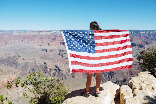 USA, arizona, Rückansicht einer Frau mit amerikanischer Flagge mit Blick auf den Grand Canyon Nationalpark — Stockfoto