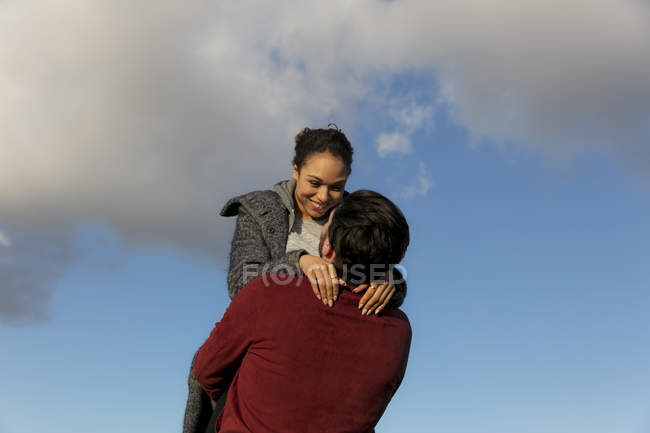 Feliz joven pareja abrazando al aire libre - foto de stock