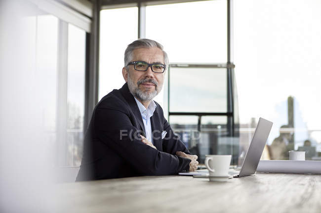 Портрет впевнено бізнесмен з ноутбук на столі в офісі — стокове фото
