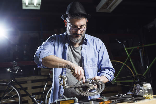 Mann arbeitet in Werkstatt an Fahrrad — Stockfoto