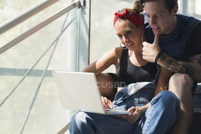 Молода пара сидить на сходах за допомогою ноутбука — стокове фото